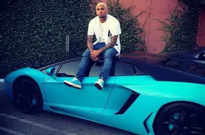 كريس براون يرتدي حذاء سماوي خلال جلوسه علي سقف سيارته أفنتادور